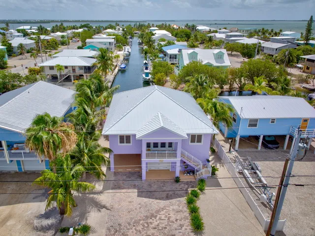 a front view of a house with yard and tree