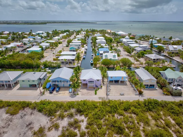 a aerial view of a house with swimming pool lawn chairs and a yard