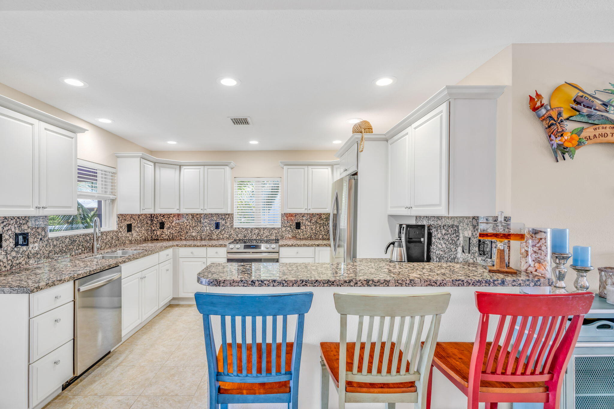 823 Indies Road Summerland Key, FL 33042 - Photo 10 of 48 a kitchen with stainless steel appliances granite countertop a stove a sink dishwasher and white cabinets with wooden floor