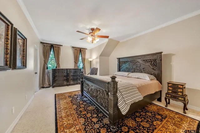 a bedroom with a large bed and a chandelier
