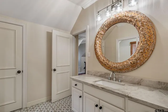 a bathroom with a granite countertop sink mirror vanity and toilet