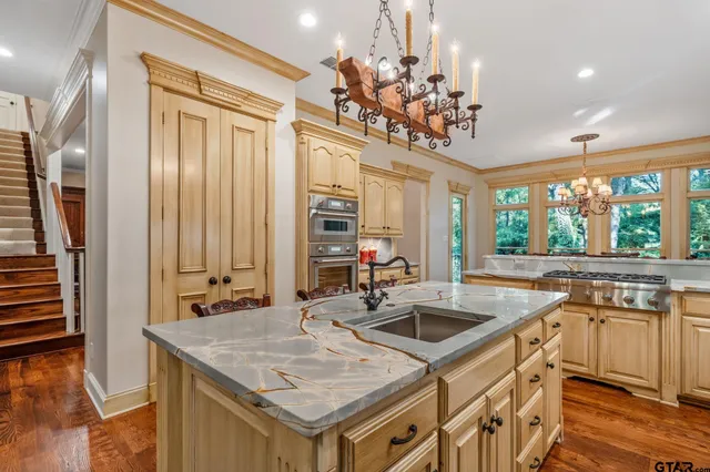 a kitchen with stainless steel appliances granite countertop a sink a stove and a refrigerator