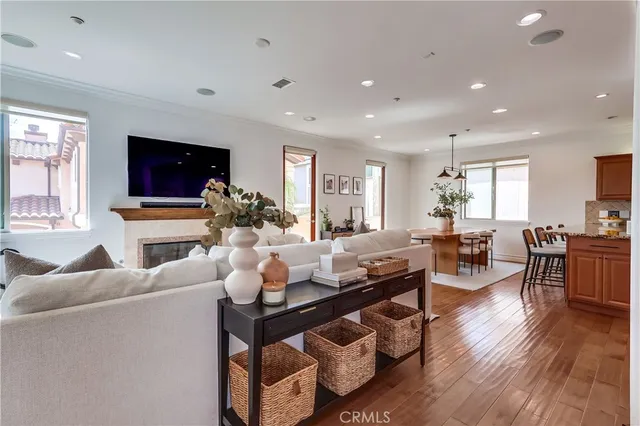 a living room with fireplace furniture flat screen tv and wooden floor
