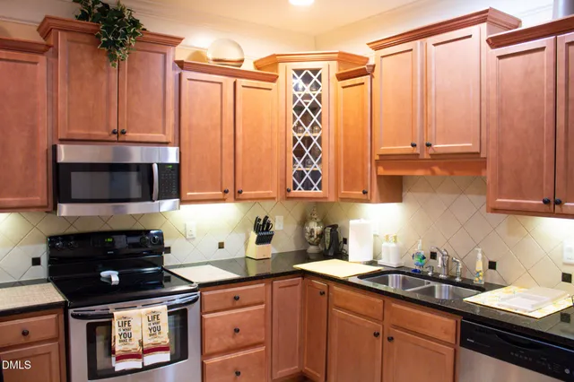 a kitchen with stainless steel appliances a stove a sink and cabinets
