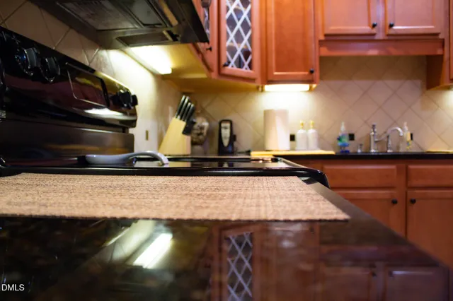 a kitchen with kitchen island granite countertop a sink a stove and a microwave