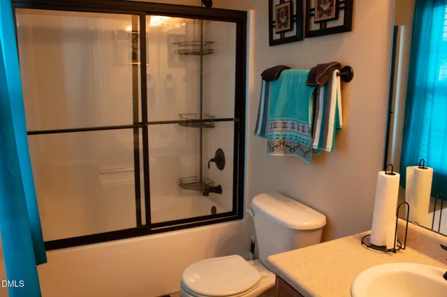 a bathroom with a granite countertop toilet and a sink