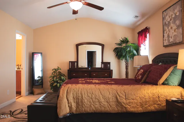 a bedroom with a large bed and a potted plant