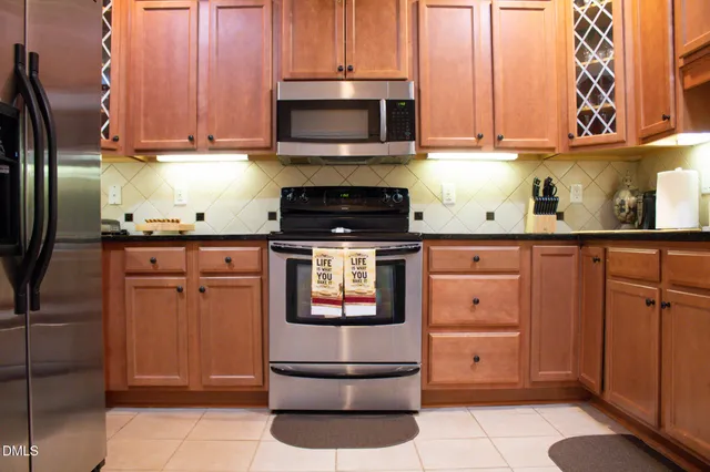 a kitchen with stainless steel appliances granite countertop a stove a microwave and a refrigerator