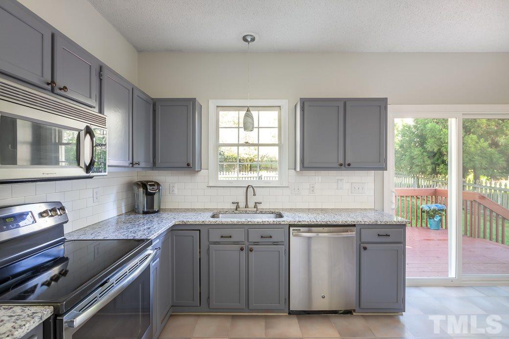 5608 Edgebury Road Raleigh, NC 27613 - Photo 5 of 11 a kitchen with granite countertop a sink stainless steel appliances and cabinets