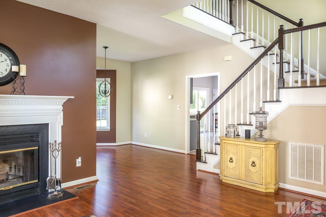 5608 Edgebury Road Raleigh, NC 27613 - Photo 7 of 11 a living room with wooden floors and a fireplace