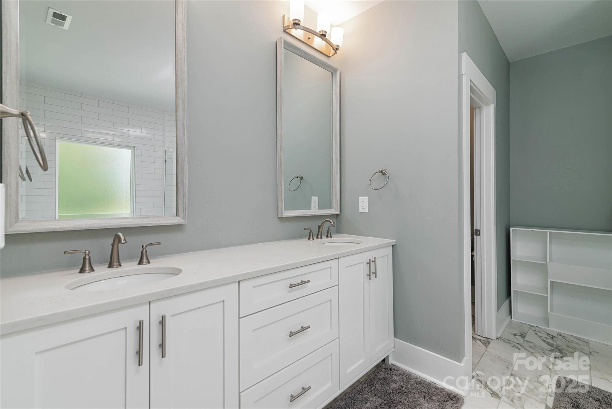 5345 Christopher Road Iron Station, NC 28080 - Photo 28 of 48 a bathroom with a double vanity sink and mirror