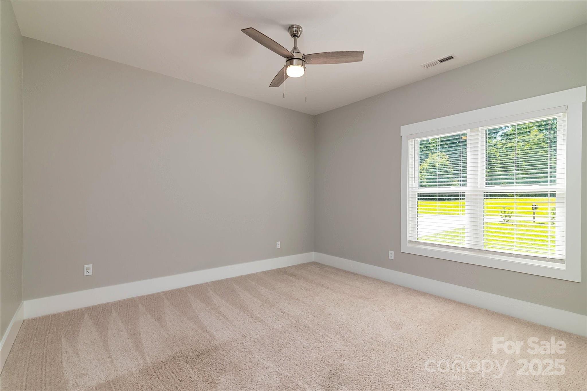 5345 Christopher Road Iron Station, NC 28080 - Photo 32 of 48 an empty room with a window and a ceiling fan