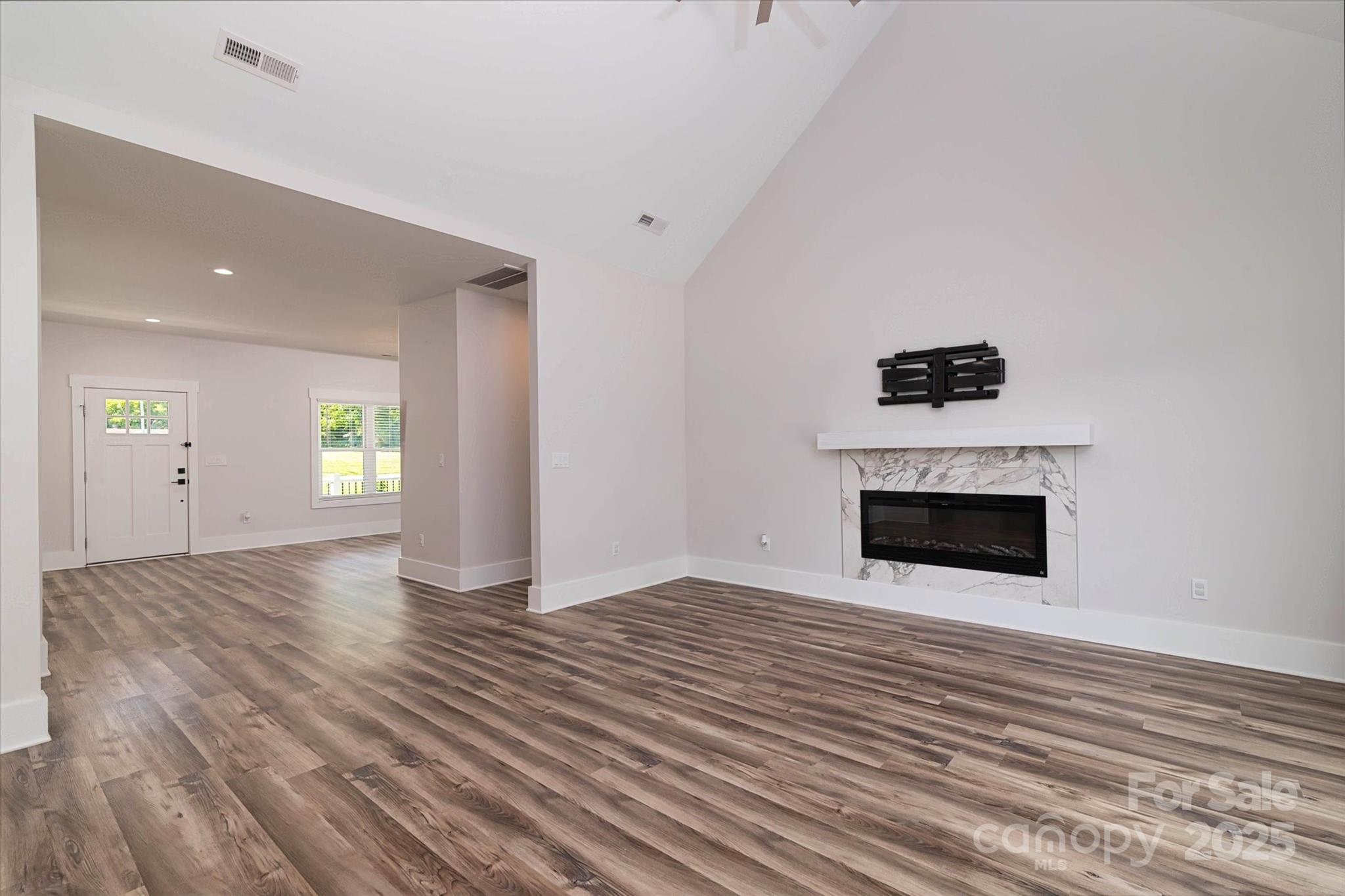 5345 Christopher Road Iron Station, NC 28080 - Photo 9 of 48 an empty room with wooden floor and fireplace
