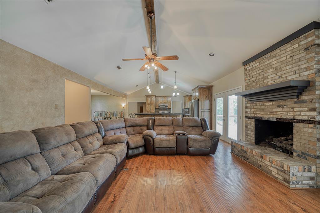 1006 Rikkity Lane Mount Pleasant, TX 75455 - Photo 3 of 39 a living room with furniture a fireplace and a chandelier