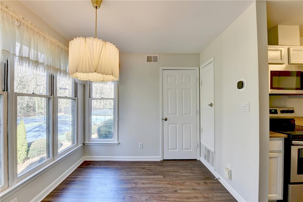 911 Garden Court, Unit 911 Atlanta, GA 30328 - Photo 11 of 41 a view of a hallway with wooden floor and a chandelier