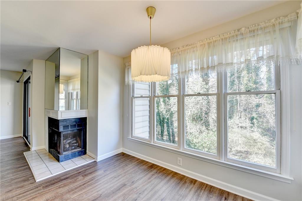 911 Garden Court, Unit 911 Atlanta, GA 30328 - Photo 13 of 41 a view of an empty room with wooden floor fireplace and a window