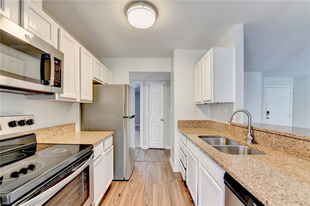 911 Garden Court, Unit 911 Atlanta, GA 30328 - Photo 16 of 41 a kitchen with stainless steel appliances granite countertop a sink stove and refrigerator