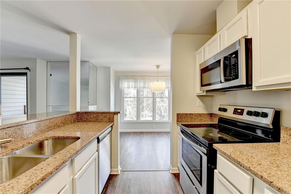 911 Garden Court, Unit 911 Atlanta, GA 30328 - Photo 18 of 41 a kitchen with stainless steel appliances granite countertop a sink stove and microwave