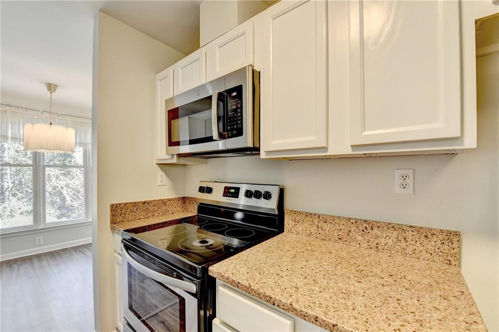 911 Garden Court, Unit 911 Atlanta, GA 30328 - Photo 19 of 41 a kitchen with stainless steel appliances granite countertop a stove and a microwave