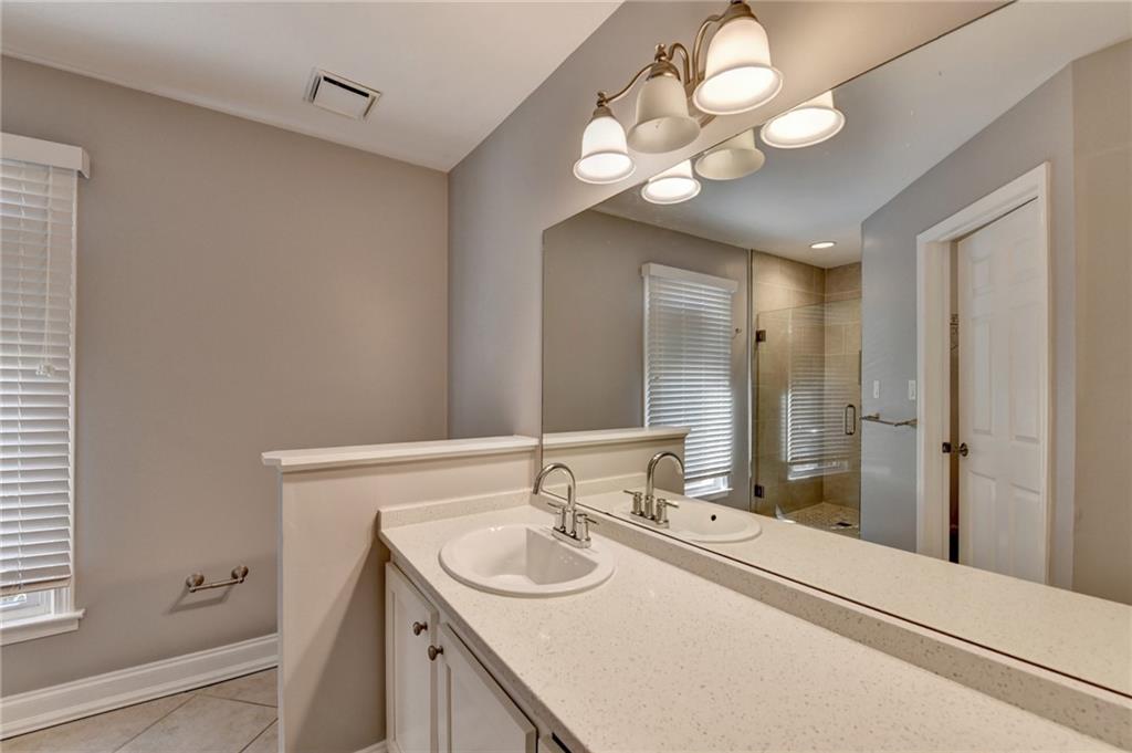 911 Garden Court, Unit 911 Atlanta, GA 30328 - Photo 31 of 41 a bathroom with a sink a large mirror and a shower