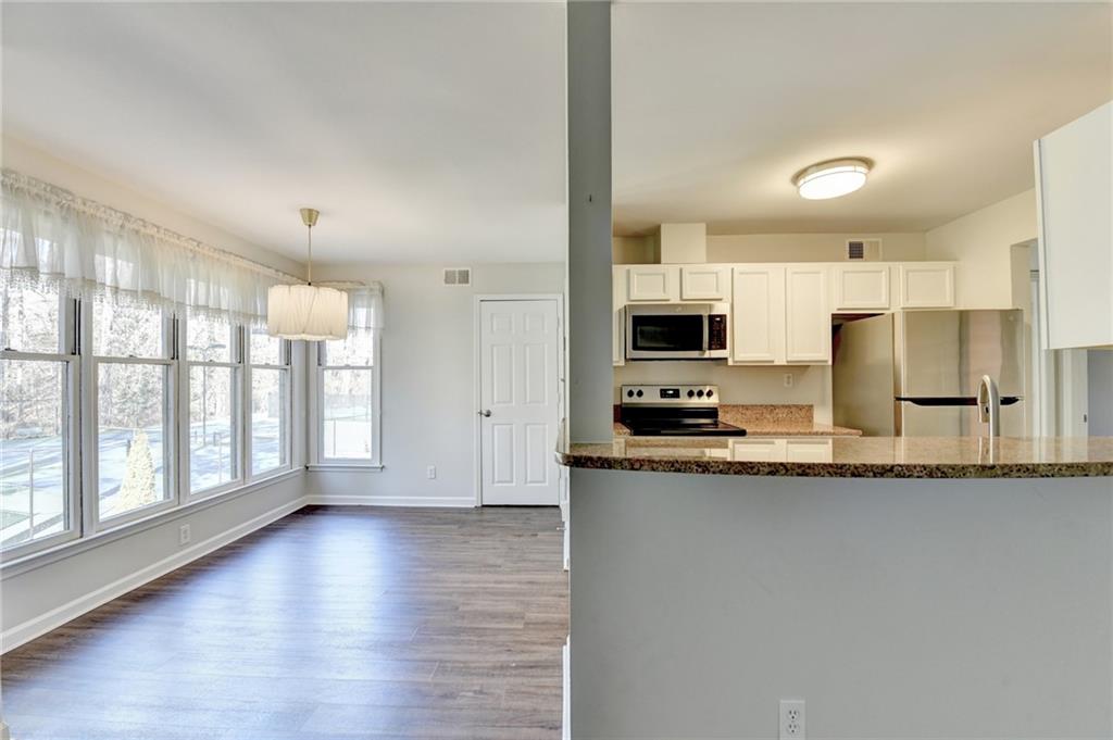 911 Garden Court, Unit 911 Atlanta, GA 30328 - Photo 9 of 41 a kitchen with stainless steel appliances granite countertop a stove a sink and a refrigerator