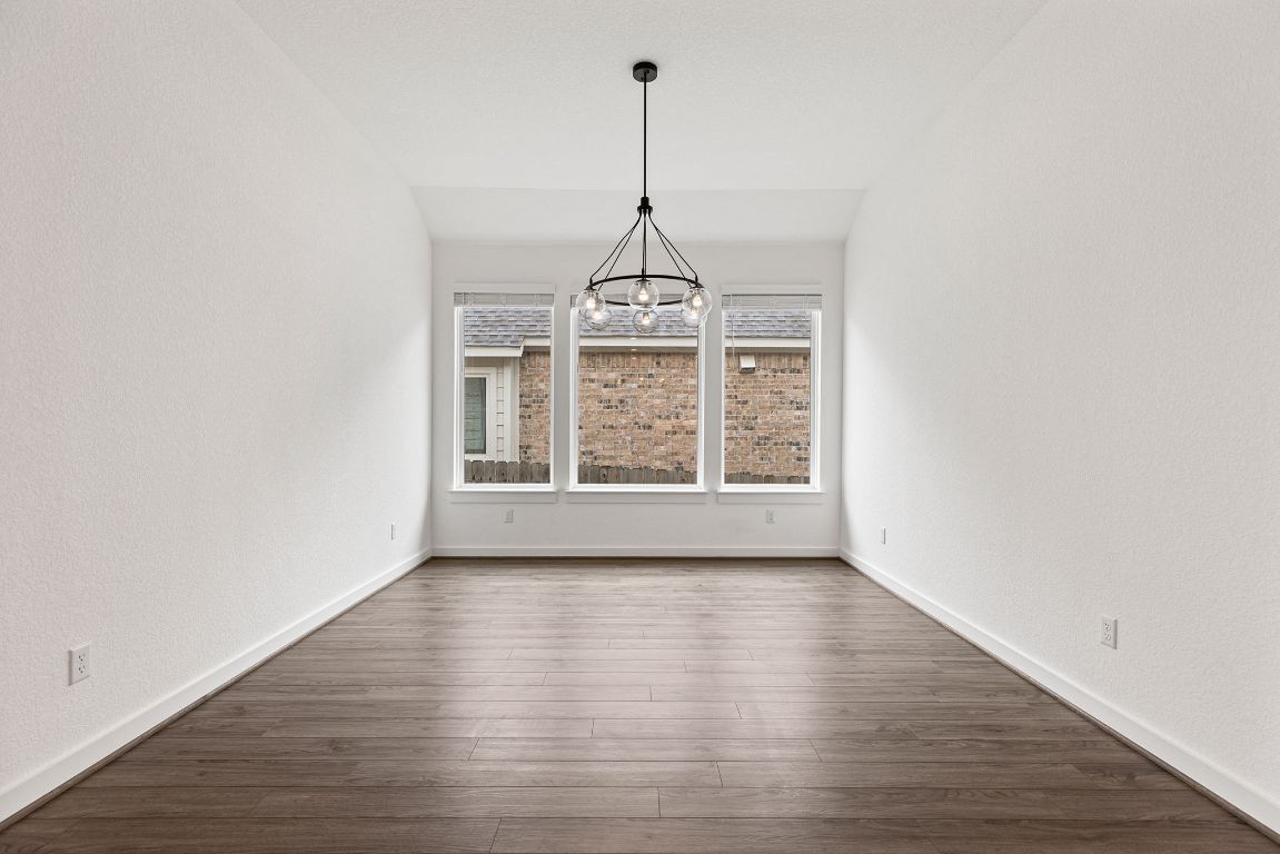 317 Independence Drive Kyle, TX 78640 - Photo 11 of 40 This Dining Area feels like the perfect blend of style and simplicity. The first thing you notice is the natural light pouring in through those large windows, giving the space an open, airy vibe.