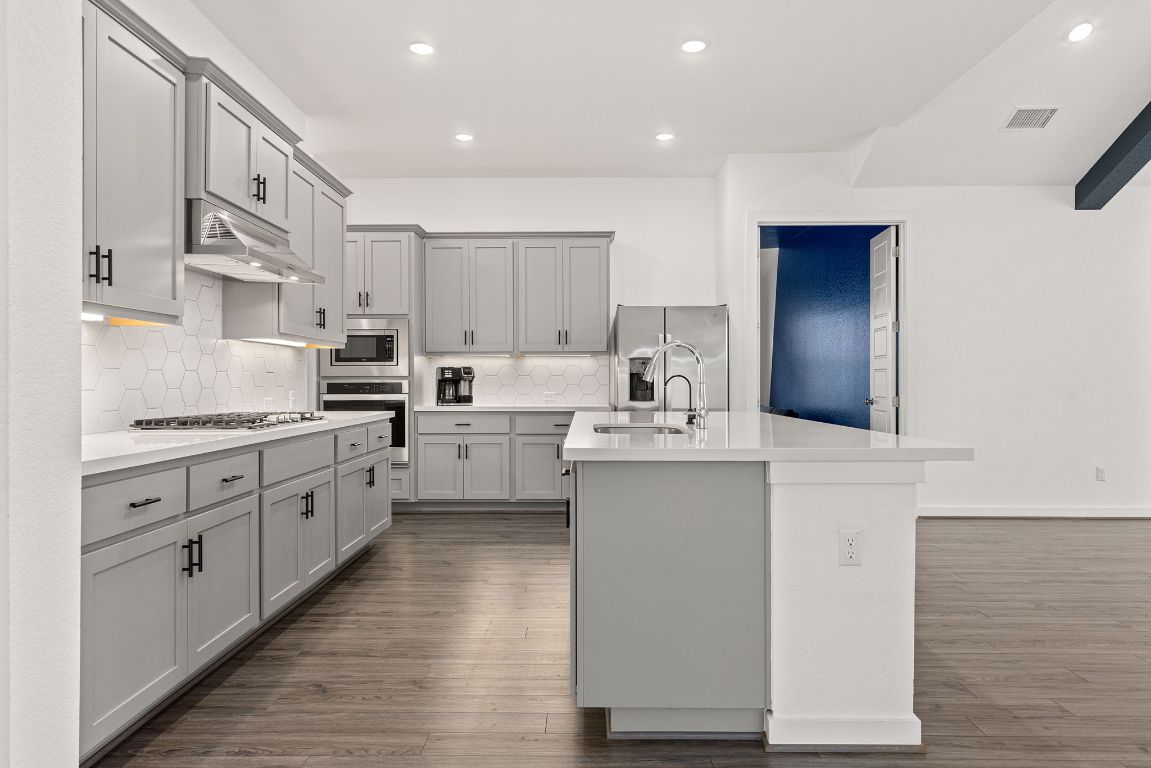 317 Independence Drive Kyle, TX 78640 - Photo 12 of 40 This Kitchen is stylish without trying too hard, with sleek gray cabinetry that pops against the bright quartz countertops.
