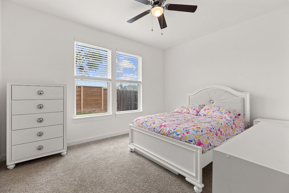 317 Independence Drive Kyle, TX 78640 - Photo 30 of 40 Bedroom #3 - Each room is designed to feel cozy yet spacious, with large windows that welcome plenty of natural light. Whether you're setting up a guest room, a kid's space, or a personal retreat, these rooms adapt to your needs effortlessly.