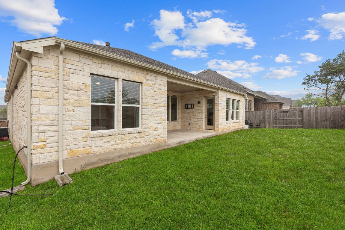 317 Independence Drive Kyle, TX 78640 - Photo 38 of 40 The stone exterior adds a touch of rustic elegance to the home’s facade, blending seamlessly with the natural surroundings.