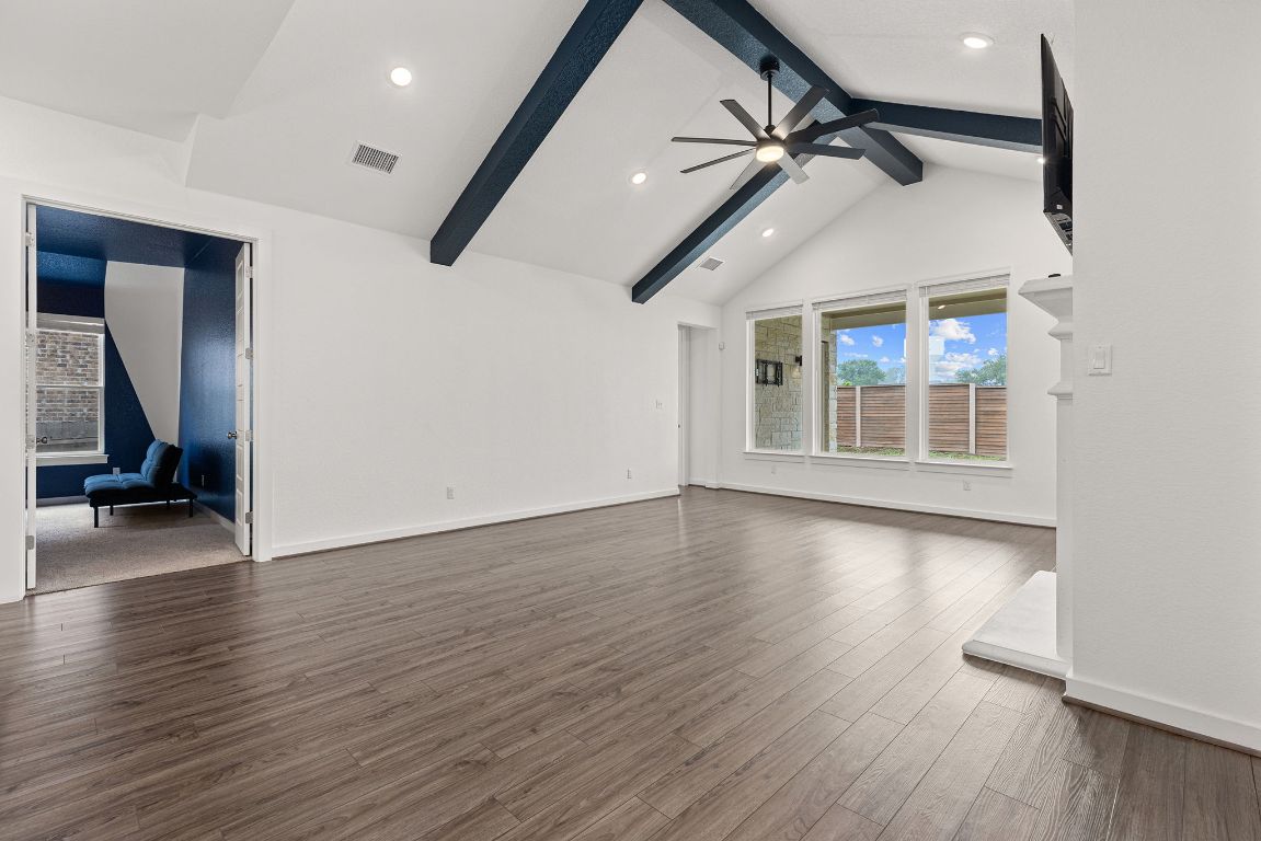 317 Independence Drive Kyle, TX 78640 - Photo 9 of 40 From the entry, your gaze naturally leads into the heart of the home—the family room. It’s impressive without being overwhelming, with soaring vaulted ceilings accented by striking dark beams that add both height and character.