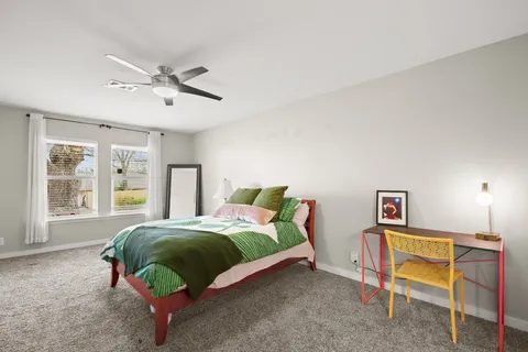 a bedroom with a bed a window and dresser