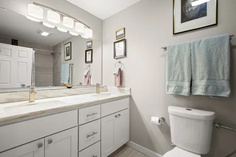 a bathroom with a toilet sink and mirror
