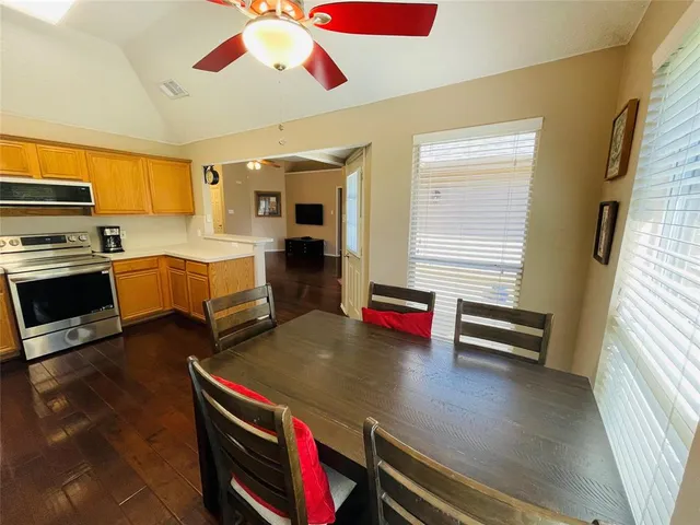 a kitchen with stainless steel appliances granite countertop a sink dishwasher stove and cabinets with wooden floor