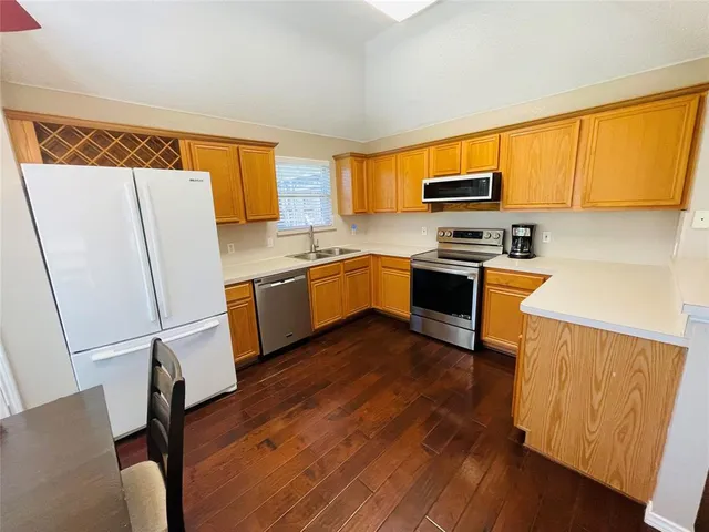 a kitchen with stainless steel appliances a stove a sink and a refrigerator