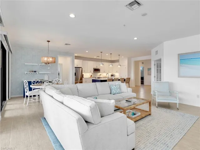 a living room with furniture and a dining table with kitchen view
