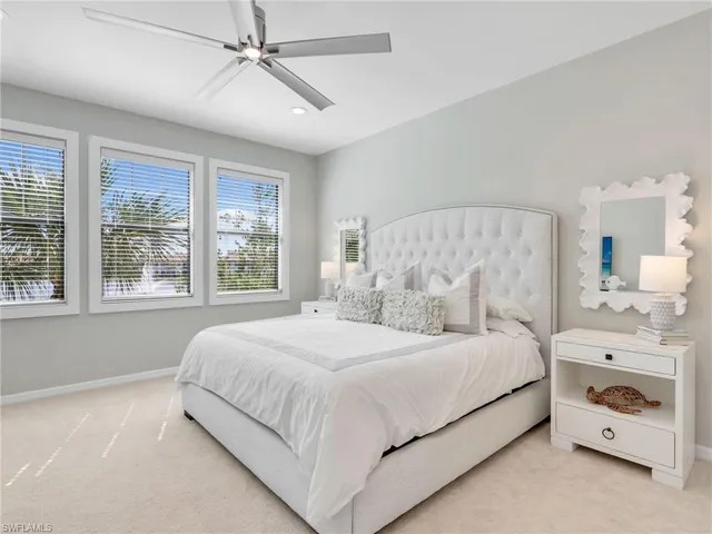 a bedroom with a bed and a chandelier fan