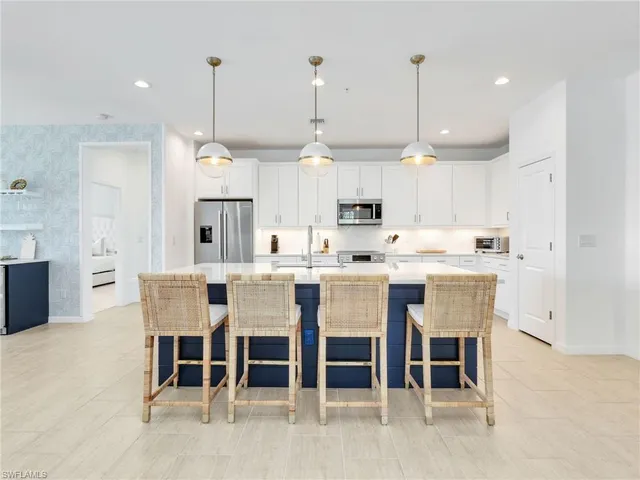 a kitchen with kitchen island a dining table and chairs