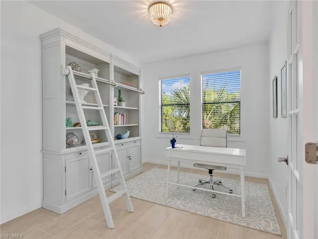 a view of a workspace with furniture and a window