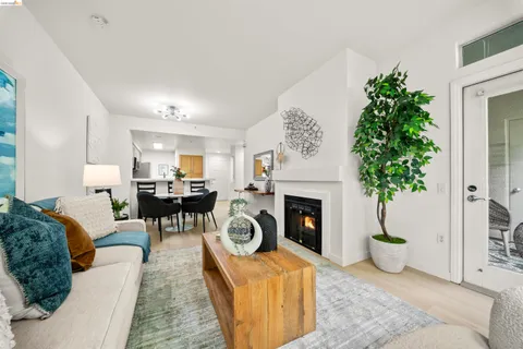 a living room with furniture a fireplace and a potted plant