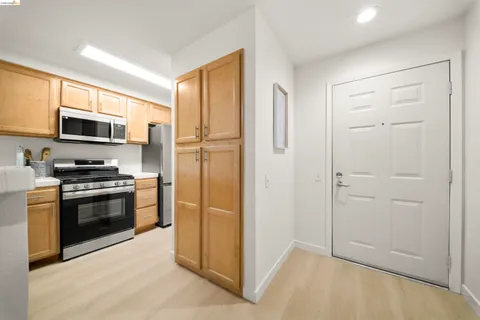 a kitchen with stainless steel appliances granite countertop a refrigerator and a stove top oven