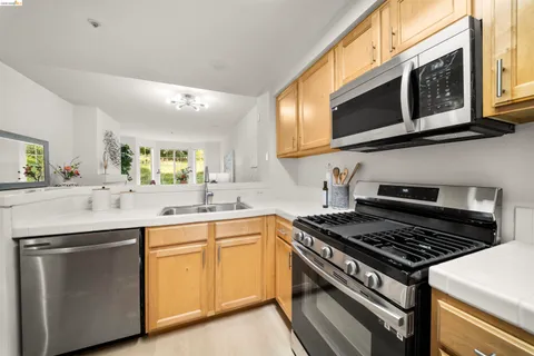 a kitchen with stainless steel appliances a sink dishwasher stove and microwave