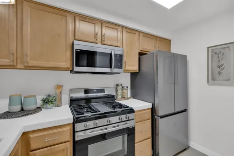 a kitchen with stainless steel appliances granite countertop a refrigerator stove and microwave