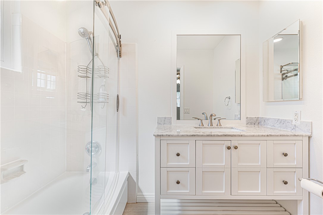 3542 Waco Avenue Simi Valley, CA 93063 - Photo 7 of 13 a bathroom with a granite countertop sink a mirror and shower