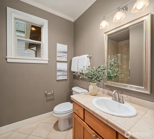 a bathroom with a granite countertop toilet a sink and mirror