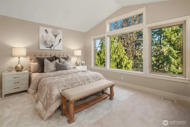 a large bed sitting in a bedroom next to a window