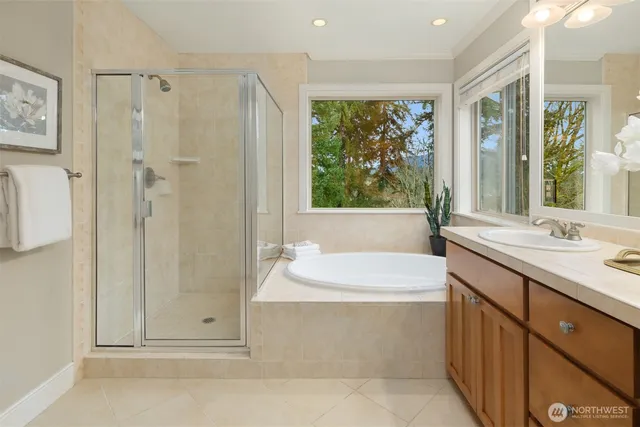 a bathroom with a tub sink and mirror