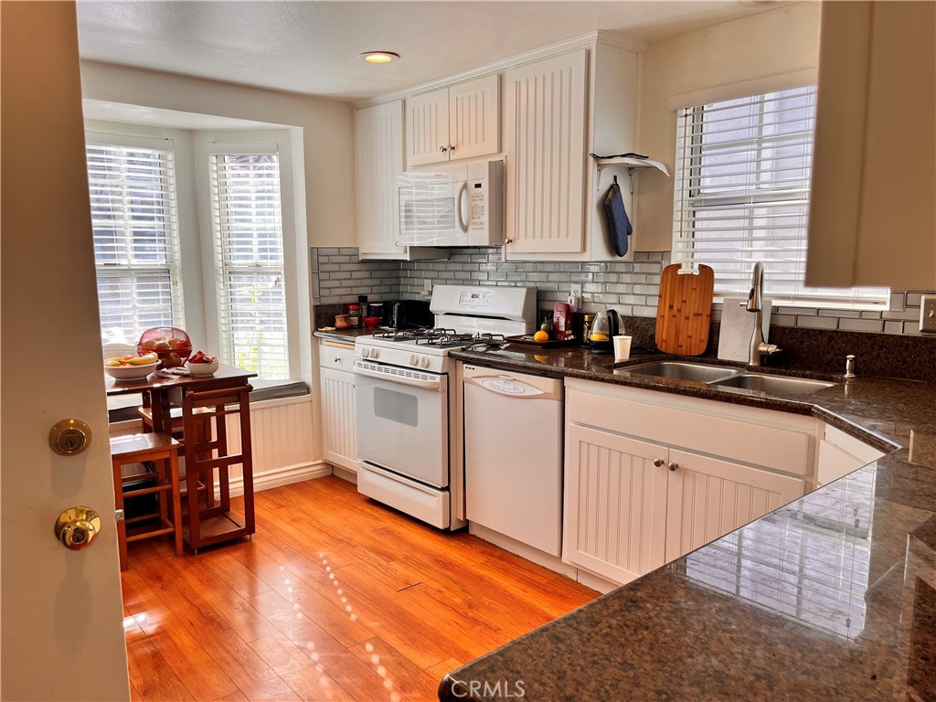 19849 Collins Road Canyon Country, CA 91351 - Photo 16 of 32 a kitchen with stainless steel appliances granite countertop a stove a sink dishwasher and a refrigerator with wooden floor