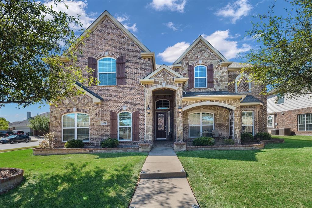 a front view of a house with yard and green space