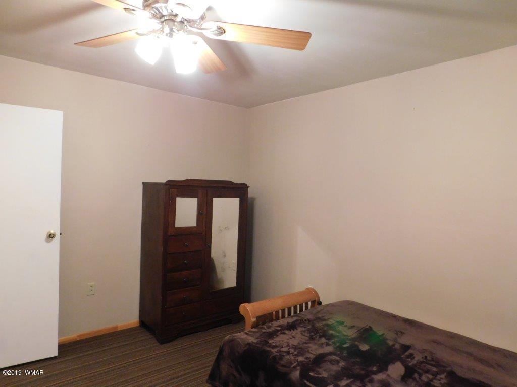 2136 Cottontail Road Overgaard, AZ 85933 - Photo 21 of 23 a bedroom with a bed and wooden floor