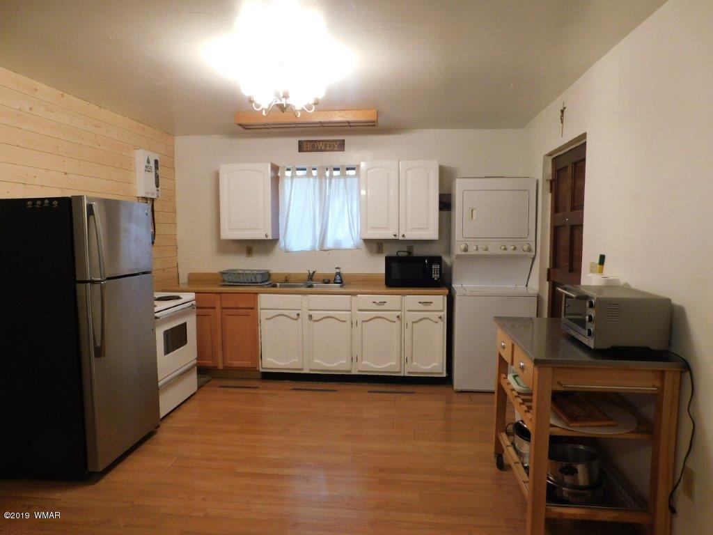2136 Cottontail Road Overgaard, AZ 85933 - Photo 8 of 23 a kitchen with a refrigerator and a stove top oven